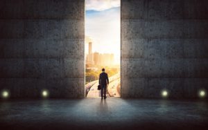 Hesitant businessman looking outside against concrete wall with huge door ,sunrise scene city skyline outdoor view .